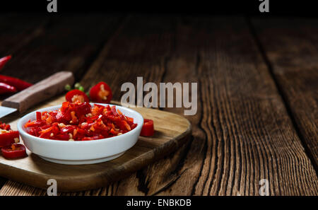 Tagliato Chilis rosso (close-up shot) su sfondo di legno Foto Stock