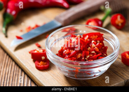 Tagliato Chilis rosso (close-up shot) su sfondo di legno Foto Stock