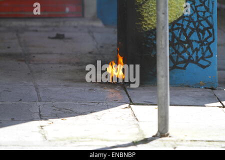 Atene, Grecia. 01 Maggio, 2015. I resti di una Molotov cocktail masterizzare su strada. L'anarchico giorno di maggio hanno marciato girato violento in Atene, quando i manifestanti hanno eretto la masterizzazione street barricate e hanno lanciato sassi e Molotov cocktail presso la polizia e premere. © Michal Debets/Pacific Press/Alamy Live News Foto Stock