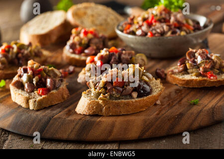 In casa mista tapenade di olive su tutto il frumento crostini Foto Stock