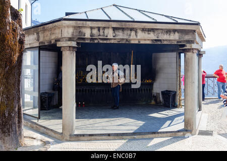 Pellegrini bruciare candele votive come adempimento dei voti in Sao Bento da Porta Aberta Santuario. Terras de Bouro, Portogallo Foto Stock