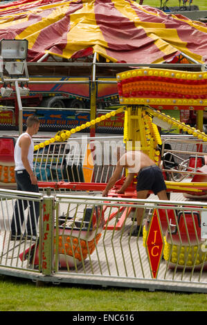 Fiera dei lavoratori mettendo insieme luna park ride Foto Stock