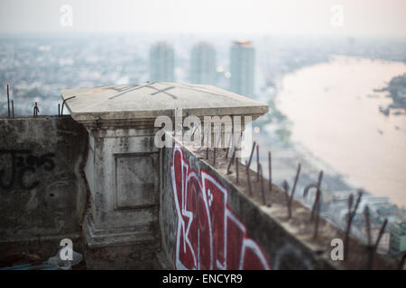 Vista verso il fiume Chao Phraya da un edificio abbandonato coperto di graffiti, Bangkok, Thailandia. Foto Stock