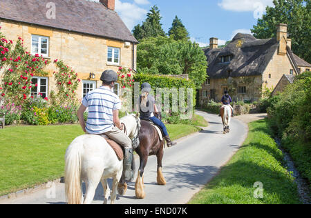 Equitazione nel villaggio Costwold di Stanton, Gloucestershire, England, Regno Unito Foto Stock