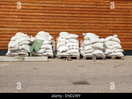 Sacchi di sabbia in cinque pile con pareti in legno in background Foto Stock