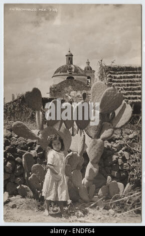 Una vera cartolina fotografica da Xochimilco, Messico, con un gruppo di bambini tra le iconiche piante di cactus. L'immagine riflette la ricchezza culturale e il paesaggio rurale della zona, catturando un momento di vita quotidiana all'inizio del XX secolo. Foto Stock