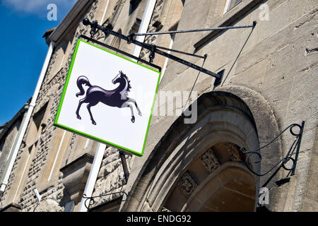 La Lloyds Bank cavallo nero segno appeso, visualizzato sopra l'ingresso,al di fuori di una filiale del Regno Unito in una giornata di sole Foto Stock