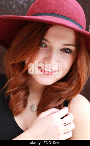 Bella giovane donna con i capelli rossi che indossa un floppy hat sorridente Foto Stock