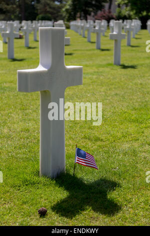 Il D-Day Cimitero Americano - Croce Bianca lapidi con bandiera americana a Coleville cimitero, la spiaggia di Omaha, Normandia Francia Foto Stock