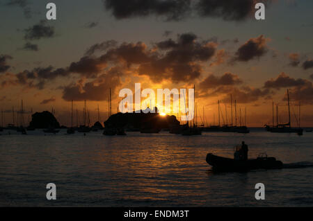 Saint-Barthélemy, French West Indies, Antille francesi, dei Caraibi: un uomo su un gommone al tramonto nella marina di Gustavia Foto Stock