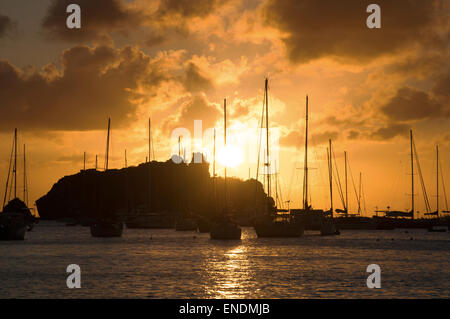 St. Barths, Saint-Barthélemy, French West Indies, Antille Francesi: Tramonto sul Mar dei Caraibi e barche a vela ancorate nel porticciolo di Gustavia Foto Stock