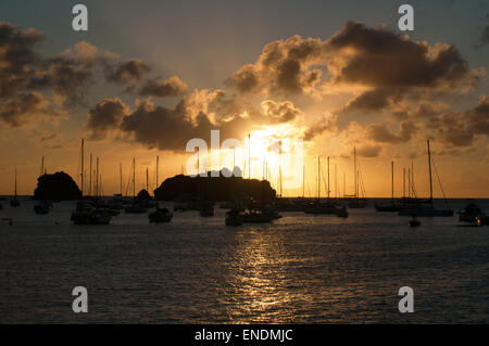 St. Barths, Saint-Barthélemy, French West Indies, Antille Francesi: Tramonto sul Mar dei Caraibi e barche a vela ancorate nel porticciolo di Gustavia Foto Stock