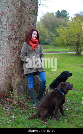 Bella giovane donna all aperto con i suoi due cani Foto Stock