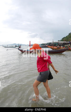 Donna Thai giocando sulla spiaggia al villaggio di pescatori di Koh Isola Phithak durante la tempesta di pioggia in Lang Suan, Chumphon Thailandia. Foto Stock