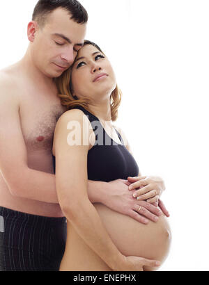 Bella futuro genitori: la sua gravidanza Asian moglie e un marito felice deliberando abbraccio insieme Foto Stock