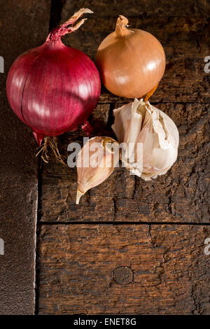 Aglio e cipolla sul vecchio tavolo in legno Foto Stock