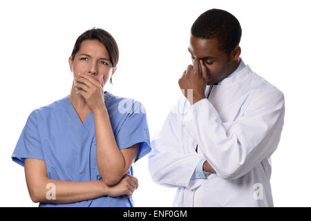 Stanchi preoccupati medico e infermiere o chirurgo in frega in piedi con le loro mani per le loro facce e le espressioni gravi dopo un lon Foto Stock