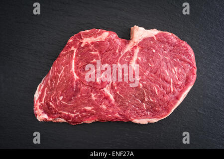 Non cotte fresche rib-eye bistecca su sfondo nero Foto Stock