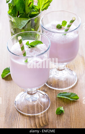 Due bicchieri con cocktail di latte decorato con foglie di menta Foto Stock