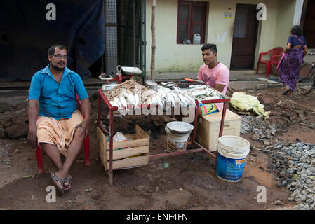 Due pescivendoli con il loro set-up store su una strada trafficata a Fort Cochin a Kochi, Kerala, India Foto Stock