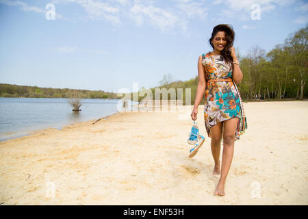 Giovane donna camminando lungo la riva del fiume Foto Stock