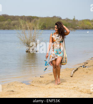 Giovane donna camminando lungo la riva del fiume Foto Stock