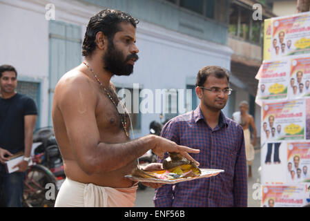 Un sacerdote Indù eseguendo una benedizione per una nuova vettura ed il suo proprietario al di fuori del Sree Poornathrayeesa Tempio. Il tempio indù è Foto Stock