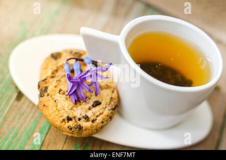 Tazza di tè con limone e i cookie su sfondo di legno. Immagine dai toni Foto Stock