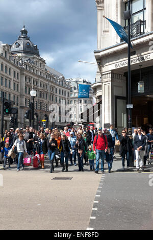 La folla che attraversa la strada a un weekend intenso in Regent Street, Londra Foto Stock