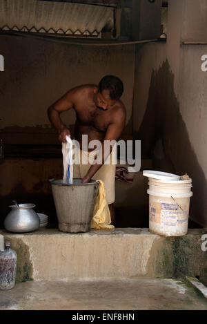 Un dipendente occupato lavando qualche servizio lavanderia presso un grande servizio lavanderia a Fort Cochin a Kochi, Kerala, India. Foto Stock