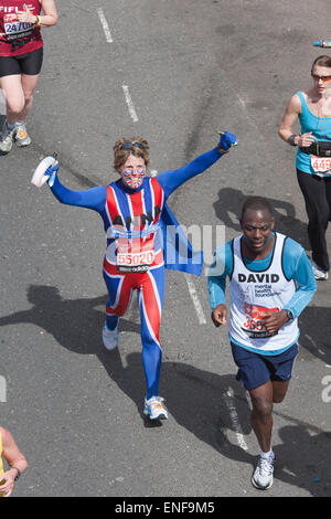 Campo principale, i runner che partecipano ad associazioni di beneficenza e divertimento guide. Corridori della maratona en route a 15,5 miglia a punto nei Docklands di Londra. Foto Stock