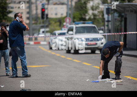 Gerusalemme. Il 4 maggio, 2015. Un israeliano forensic poliziotto (R) ispeziona il sito di un tentativo di accoltellato a Gerusalemme, il 4 maggio 2015. La sicurezza di Israele guardie sparato e ferito un uomo palestinese che avrebbe cercato di persone pugnalata a Gerusalemme il lunedì, un portavoce della polizia ha confermato. © JINI/Xinhua/Alamy Live News Foto Stock