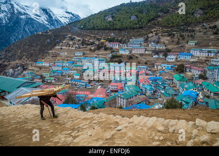 Namche Bazaar, nepal - 9 marzo 2015: la vista di un portiere nepalese trasporta un carico pesante Foto Stock