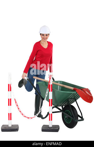 Tradeswoman spingendo una carriola Foto Stock