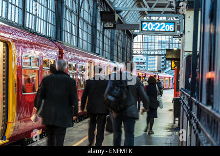 Pendolari in movimento per andare a casa su una piattaforma del treno da London Waterloo Stazione ferroviaria Foto Stock
