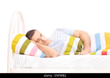 Giovane uomo dorme in un letto ricoperto con un manto isolati su sfondo bianco Foto Stock