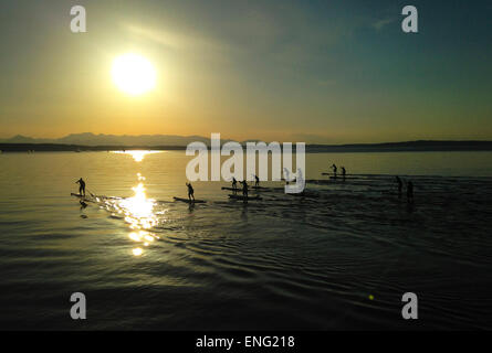 Persone paddleboarding sotto il cielo al tramonto Foto Stock