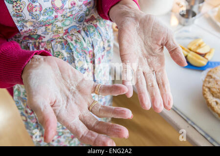 Close up di farina sulle mani di vecchi donna caucasica Foto Stock