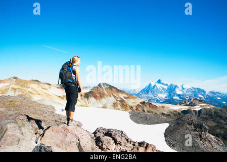 Donna ammirando le montagne nel paesaggio remoto Foto Stock