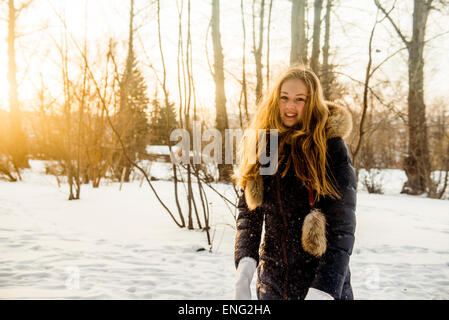 La donna caucasica giocando in campo nevoso Foto Stock