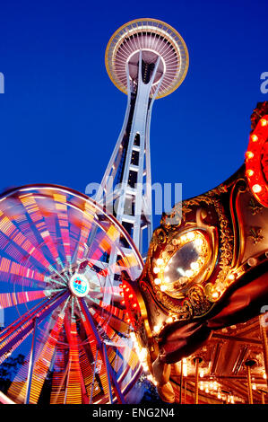 Basso angolo di vista lo Space Needle, ruota panoramica Ferris e carosello sotto il cielo notturno, Seattle, Washington, Stati Uniti Foto Stock