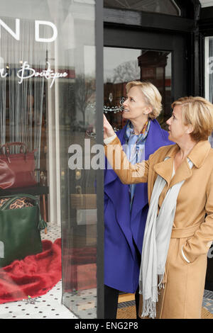 I vecchi donne caucasici window shopping nel negozio di abbigliamento Foto Stock