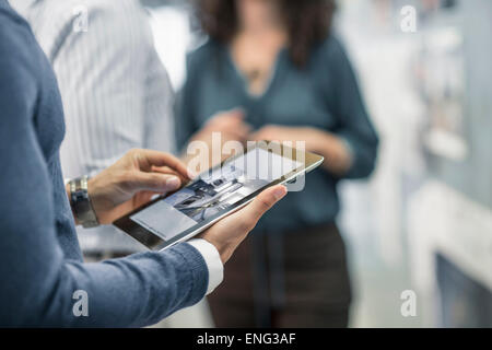 Imprenditore con tavoletta digitale in ufficio Foto Stock