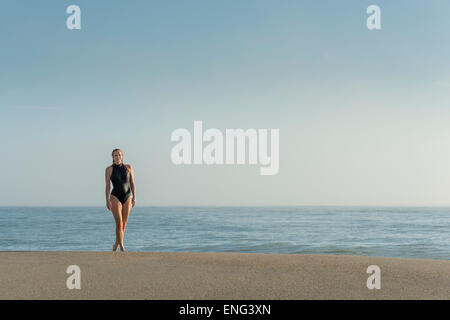 La donna caucasica indossando il costume da bagno sulla spiaggia Foto Stock