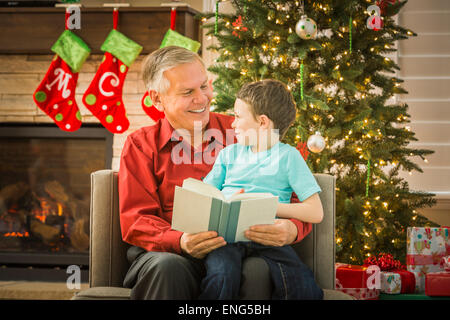 Nonno caucasica la lettura al nipote a Natale Foto Stock