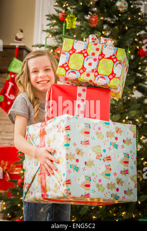 Ragazza caucasica holding pila di regali di Natale Foto Stock