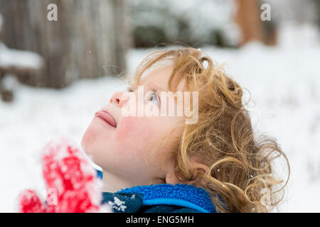 Ragazzo caucasico cattura i fiocchi di neve sulla linguetta Foto Stock