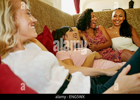 Donna sorridente ridere sul divano Foto Stock