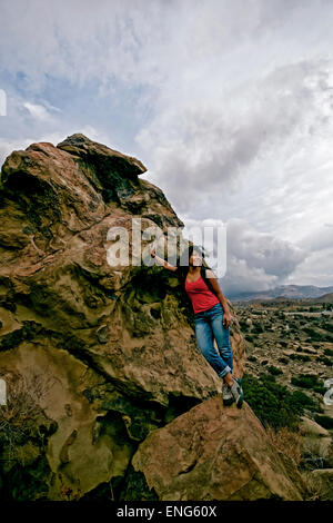 Donna ispanica permanente sulla formazione di roccia Foto Stock