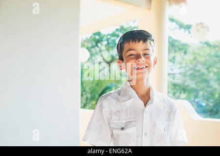 Razza mista ragazzo sorridente sul portico Foto Stock